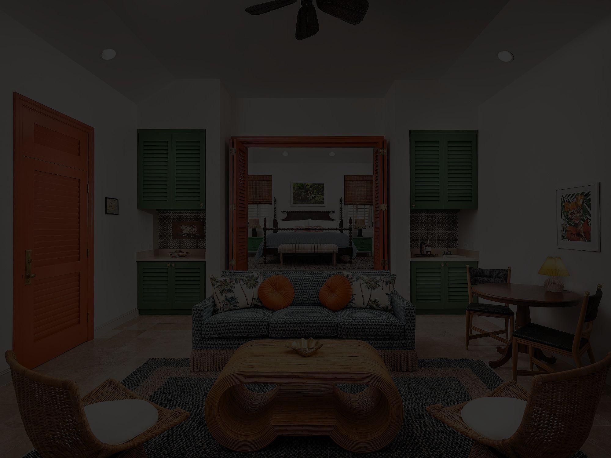 A cozy living room with a sofa facing a coffee table, two chairs, green cabinets, and a view into a bedroom through a doorway, dim lighting.