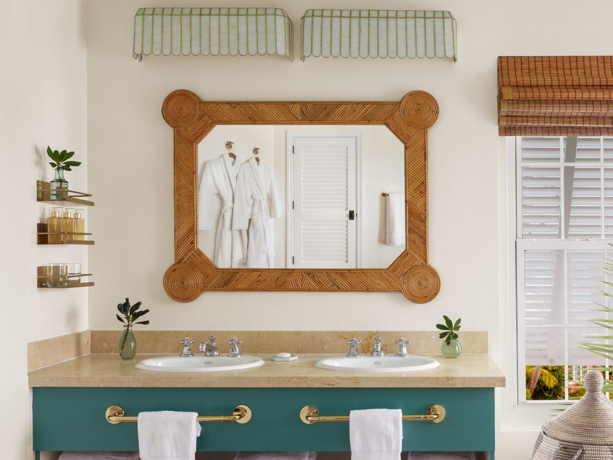 This is a contemporary bathroom with a large mirror, double sink vanity, bathtub, and woven blinds, featuring natural and wooden accents.
