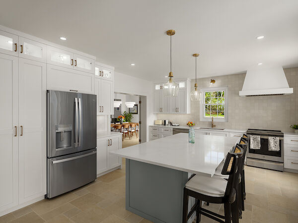 A bright, modern kitchen with white cabinets, stainless steel fridge, large island with seating, pendant lights, and a clean, airy feel.