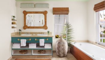 A bathroom with a double sink, large mirror, bathtub, decorative vase, plants, shelves, towels, blinds, and bathrobes on hooks is shown.