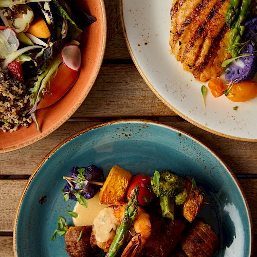 The image shows three plates of food: a salad with mixed greens, grilled meat with vegetables, and a chicken dish with veggies.